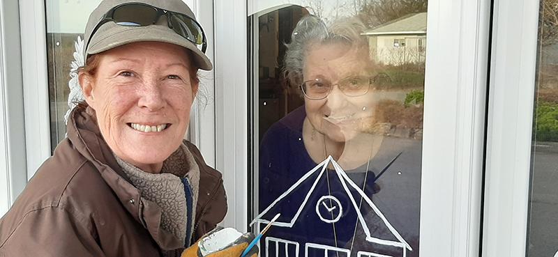 It takes a village. Local artist is using village scenes to lift spirits, decorate storefronts